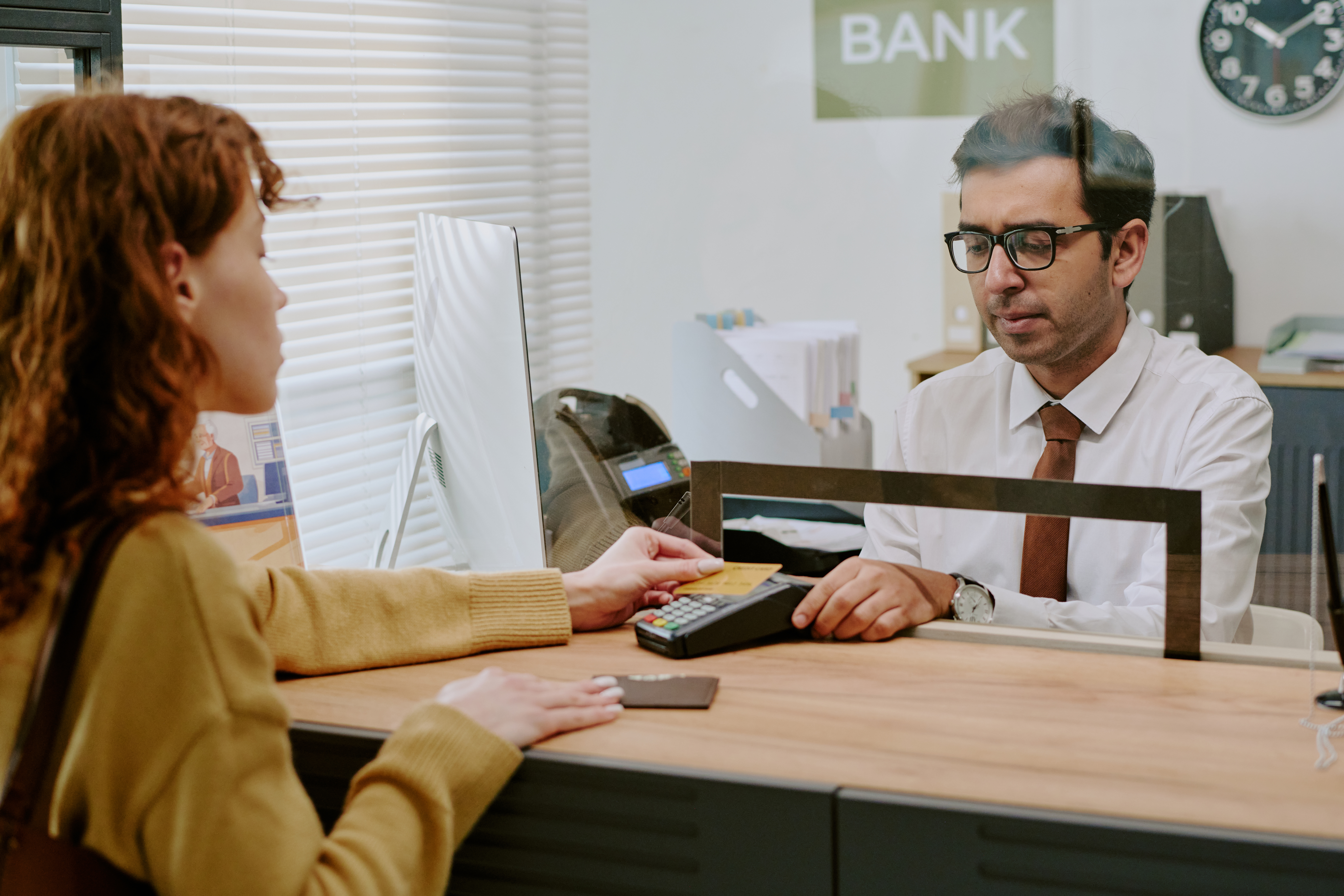 customer engaging with bank teller through counter 2025 06 05 21 41 28 utc